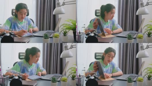 亚洲少女使用平板电脑，同时在家在线学习。高清在线视频素材下载