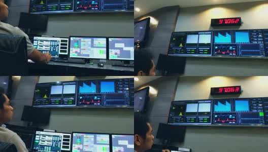 慢镜头:男性亚洲工程师正在一个被控制的电力系统中工作高清在线视频素材下载