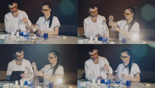 两名技术人员或科学家在化学实验室用烧杯里的彩色溶液做实验高清在线视频素材下载