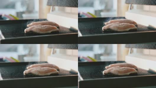 新鲜的鱼排在热腾腾的烤架上炸着，散发着烟熏的香味高清在线视频素材下载