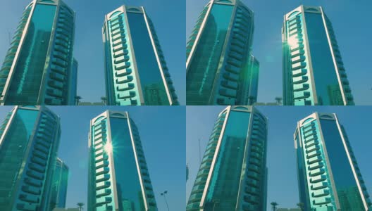 阳光照在摩天大楼的窗玻璃上。在沙迦现代城市的现代摩天大楼的玻璃幕墙反射阳光高清在线视频素材下载