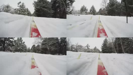 概念冬季圣诞森林。在下雪的冬天越野滑雪。冬季圣诞森林低角度视图。慢慢地下起了一场大雪。移动的摄像机安装在旧的越野滑雪板上。第一人称视角- POV高清在线视频素材下载