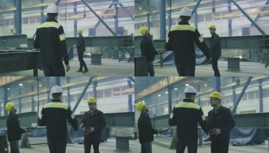 在一家重工业工厂，工程师戴着安全帽与工人们握手致意。高清在线视频素材下载