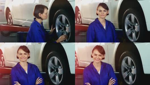 女机械师在检查一个轮子，对着镜头微笑高清在线视频素材下载
