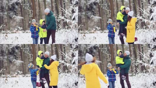 冬日森林里的全家福。幸福的家庭和宠物在白雪覆盖的树的背景下高清在线视频素材下载