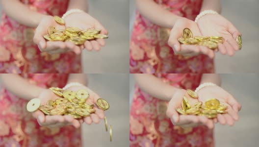 中国古代金币飘浮到身穿中国传统服饰的年轻女子手中，金字上寓意“钱是comingâ，过年快乐”的概念。高清在线视频素材下载