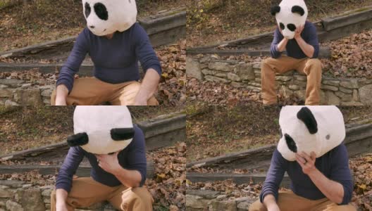 一名戴着熊猫头面具的男子假装伤心哭泣高清在线视频素材下载