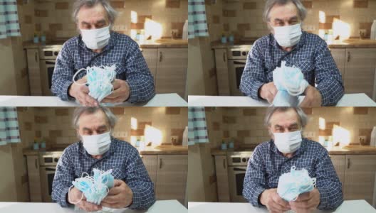 防病毒保护。新型冠状病毒肺炎那位戴着医用防护面罩的老人正坐在厨房的一张桌子旁。高清在线视频素材下载