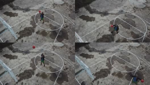 在无人机的镜头下，一名亚裔中国老人在篮球场练习篮球高清在线视频素材下载