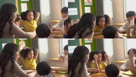亚洲学校的老师在课堂上帮助学生高清在线视频素材下载
