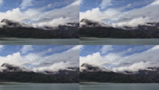 低云层，在阿拉斯加冰川湾国家公园的雪山之上。高清在线视频素材下载