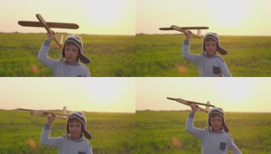 可爱的小男孩戴着头盔，飞机飞行员和玩具木制飞机在田野里奔跑。孩子大梦想飞翔，在夏天的大自然中旅行在户外日落，旅行自由，慢镜头高清在线视频素材下载