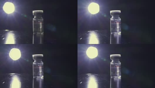 黑色背景下Covid-19疫苗瓶的特写高清在线视频素材下载