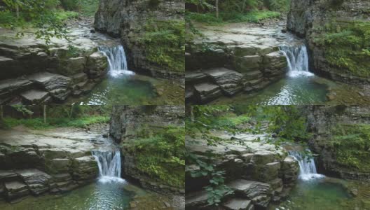 令人惊叹的风景，美丽的山河瀑布与白色泡沫水从岩石悬崖下降在夏季雨林。高清在线视频素材下载