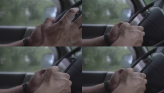 成年男性手持智能手机，进入车内玩数字游戏。高清在线视频素材下载