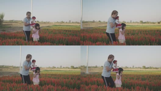一个亚洲女人带着两个女儿在日落时分的向日葵农场。高清在线视频素材下载