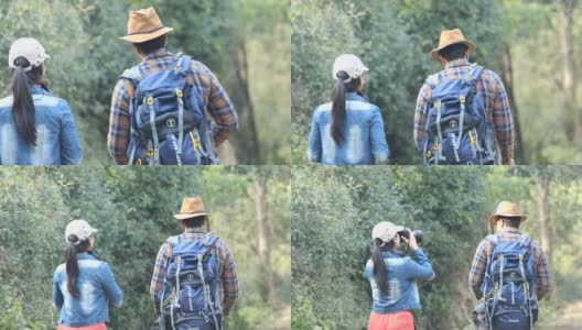 一对年轻夫妇在森林徒步旅行时用相机拍照高清在线视频素材下载