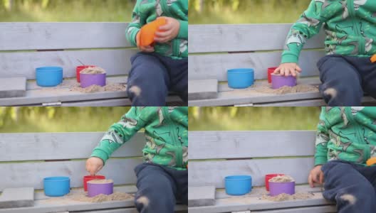 小手摸不清的小男孩，小男孩在玩沙盒沙塑料模具高清在线视频素材下载