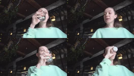 在咖啡馆喝水杯的漂亮女人高清在线视频素材下载