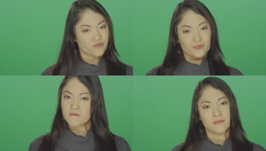 美丽的年轻亚洲女人看起来恼怒和生气，在一个绿色屏幕的工作室背景高清在线视频素材下载