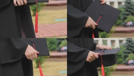 毕业日，女学生身着长袍，手拿带流苏的学位帽高清在线视频素材下载