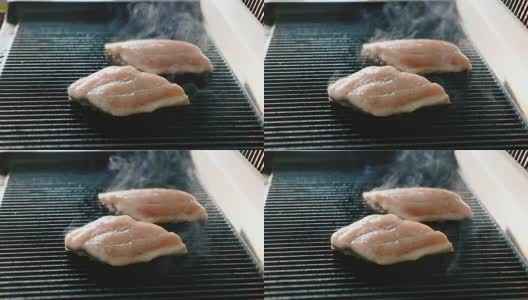 新鲜的鱼排在热腾腾的烤架上炸着，散发着烟熏的香味高清在线视频素材下载