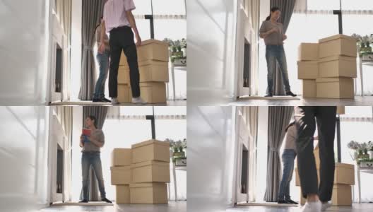 一对搬着搬家箱子的夫妇搬进了他们的新房子高清在线视频素材下载