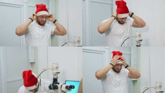 一名男子在诊所戴上圣诞帽。微笑的男子在圣诞节拜访眼科医生。男性病人在眼科咨询。高清在线视频素材下载