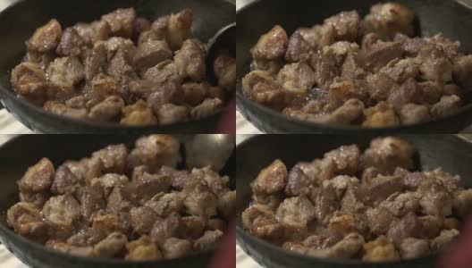 Сooking脆炸猪肉。在加热的铁煎锅里炸肉片的特写高清在线视频素材下载