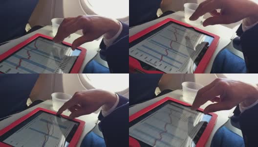 一名商人在商用飞机上用平板电脑工作高清在线视频素材下载