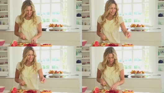 一个女人在厨房里切夏天的新鲜水果高清在线视频素材下载