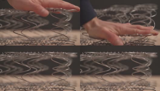 一位专家检查床垫线圈的灵活性的演示视频。家具制造的概念高清在线视频素材下载
