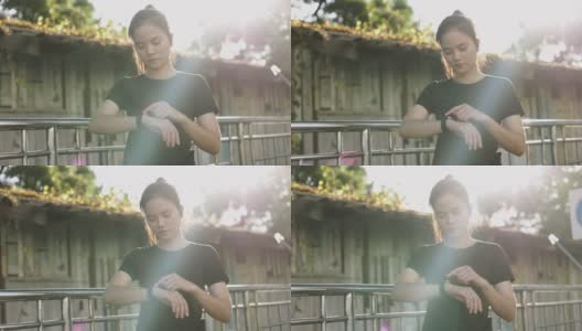 迷人的年轻亚洲女运动员在智能手表上查看心率。日落时分在街上慢跑锻炼的生活方式。高清在线视频素材下载