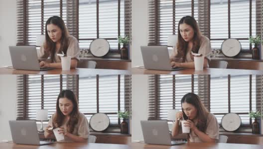 一名亚洲女性，她在家里的客厅里用笔记本电脑在桌子上工作，吃着面条。高清在线视频素材下载