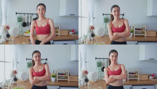 亚洲活跃女人的肖像在运动服看相机在屋里。美丽的运动女孩喜欢吃干净的沙拉，在家里和交叉双臂的健康运动后。饮食和健康食品的概念。高清在线视频素材下载