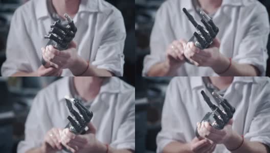 一位科学家工程师正在测试一个电子仿生假肢。他移动机械手臂的塑料手指。现代修复技术。科学家手中的控制论之手高清在线视频素材下载