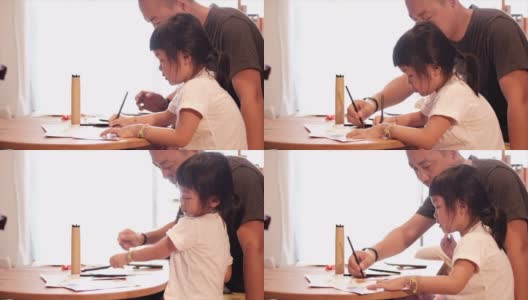 一个亚洲女孩和父亲在家画画高清在线视频素材下载