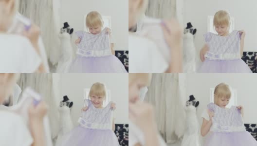 金发女孩6岁看着她新的优雅的裙子。看到镜子里的映像高清在线视频素材下载