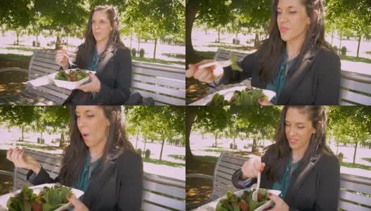 一名年轻女子在公园里用可生物降解的外卖盒吃健康沙拉高清在线视频素材下载