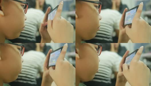 亚洲男孩用智能手机玩数字游戏高清在线视频素材下载