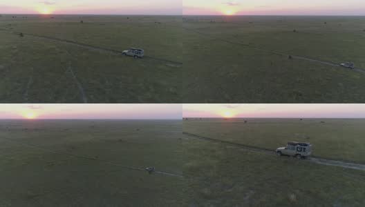 狩猎车在夕阳下穿过博茨瓦纳的草原高清在线视频素材下载