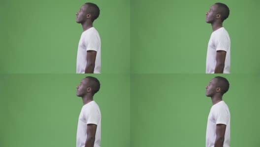 在绿色背景下的年轻非洲人的侧面视图高清在线视频素材下载