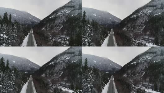 一辆黑色汽车沿着河边的乡村森林公路行驶，雪天空中拍摄高清在线视频素材下载