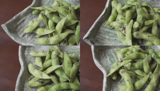 煮熟的绿色有机毛豆与盐翻，日本食物高清在线视频素材下载