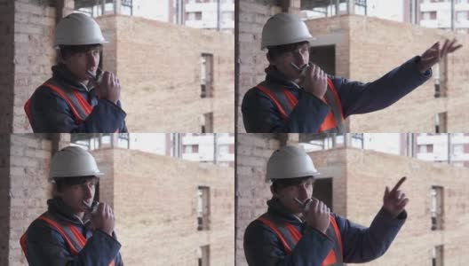 一个戴着白色防护帽的建筑工人正在用对讲机进行谈判。建筑测量和建筑重建。高清在线视频素材下载