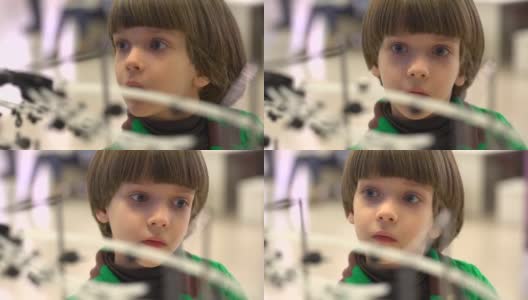在第四届俄罗斯科学节上为儿童展示的机器人。该活动旨在普及科学和展示技术进步。教育，儿童，技术，科学和人的概念-肖像的一个小男孩在机器人高清在线视频素材下载