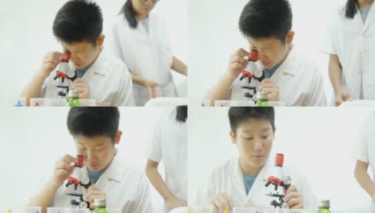 亚洲小学生穿着实验服一起在科学课上使用显微镜，教育理念。高清在线视频素材下载