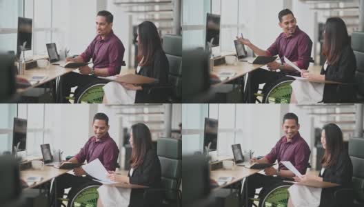坐在轮椅上的印度商人与他的中国女同事在创意办公室讨论高清在线视频素材下载