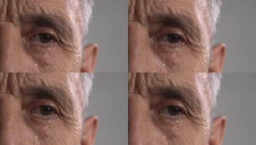 满脸皱纹的男人脸上流着眼泪。这位老人的半张脸特写。高清在线视频素材下载