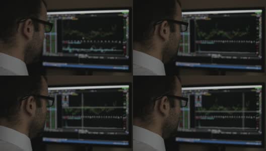 商人坐在电脑上，用电脑显示交易图形，股票交易所交易图形屏幕背景，商业金融和外汇概念。PC显示器显示模糊的饲料页。高清在线视频素材下载
